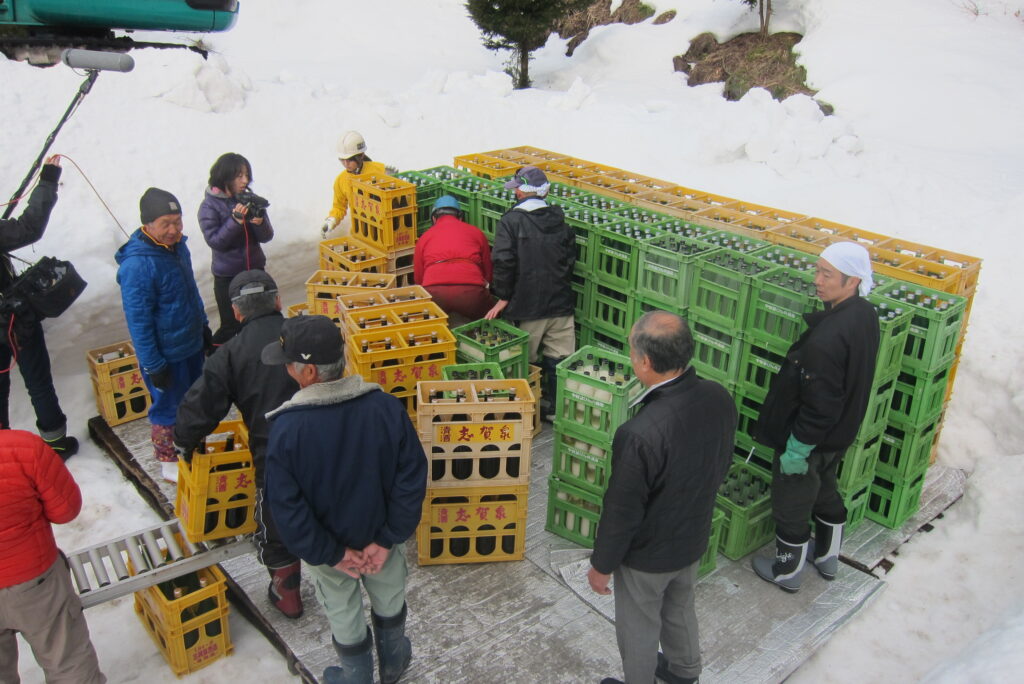 木島平のこだわりの地酒「内山の雫」の雪中貯蔵酒を雪に埋める作業